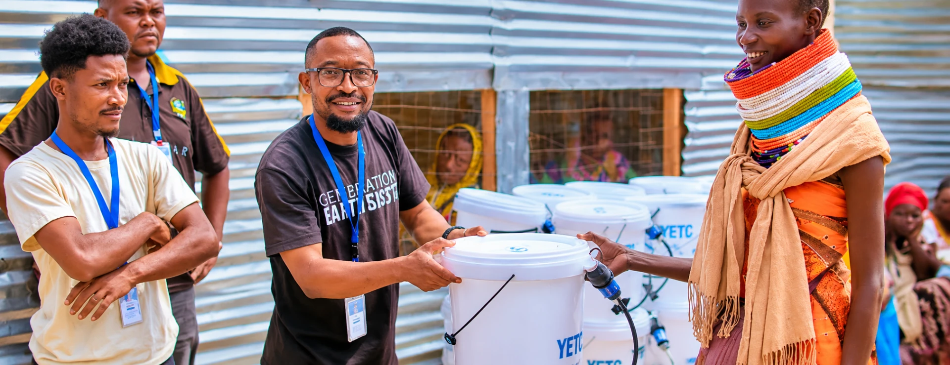 Volunteer handing a Safer Cleaner Water filtration bucket to a smiling community member
